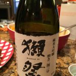 テーブルに置かれたワインボトルとグラスに入った飲み物