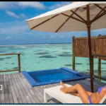 傘をさして椅子に座って海を見ている