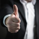白いバックグラウンドの前に立っている人の手