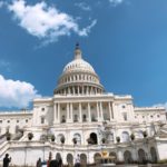 建物の前の広場にいる人たち、背景はアメリカ合衆国議会議事堂
