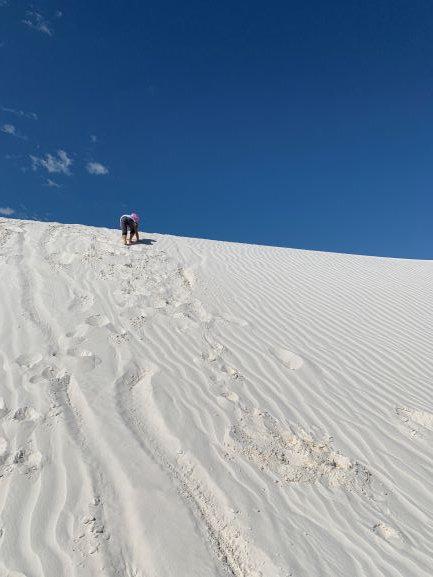 砂丘に立っているスキーヤー、背景はホワイトサンズ国定記念物