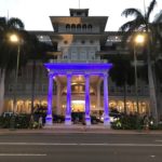 建物の前の道路を走る車のライト