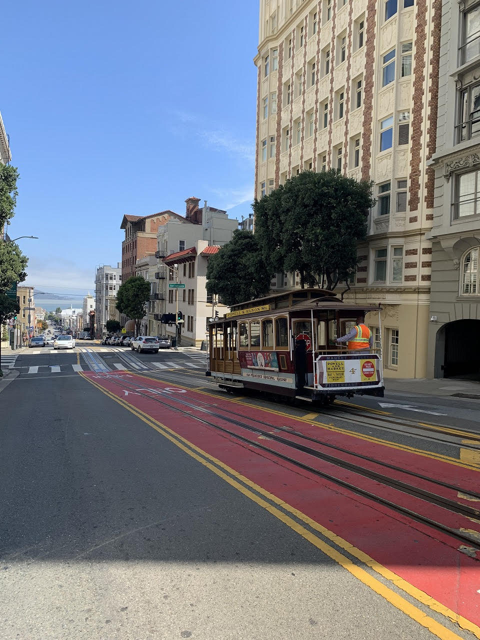 建物の前の道路を走っている電車