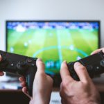 テレビゲームのリモコンを持っている手