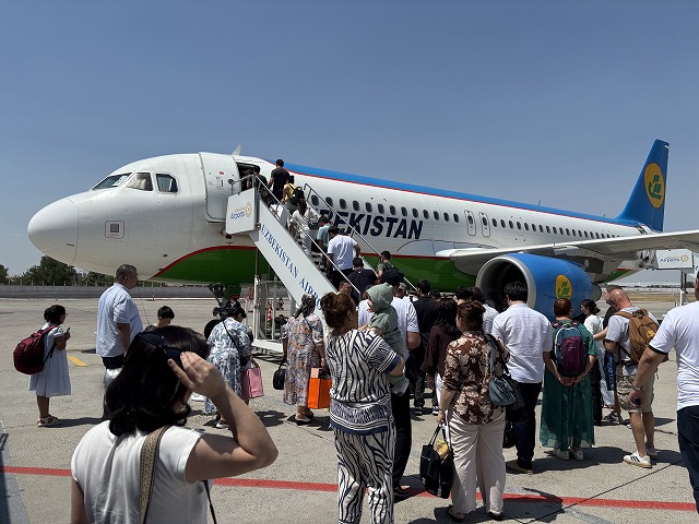空港の駐機場にとまっている飛行機を見ている人たち