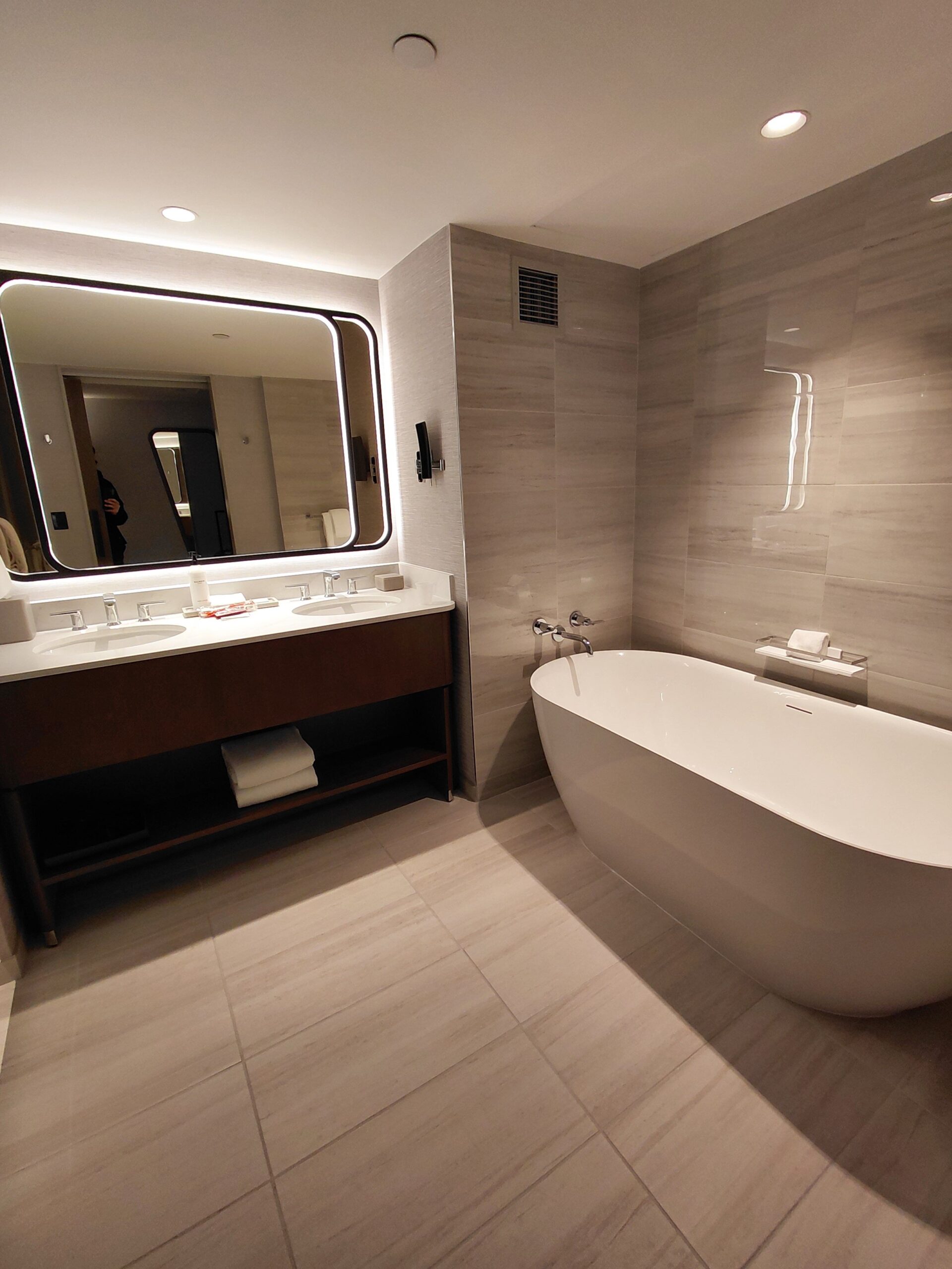 タイル床と白い壁があるバスルーム