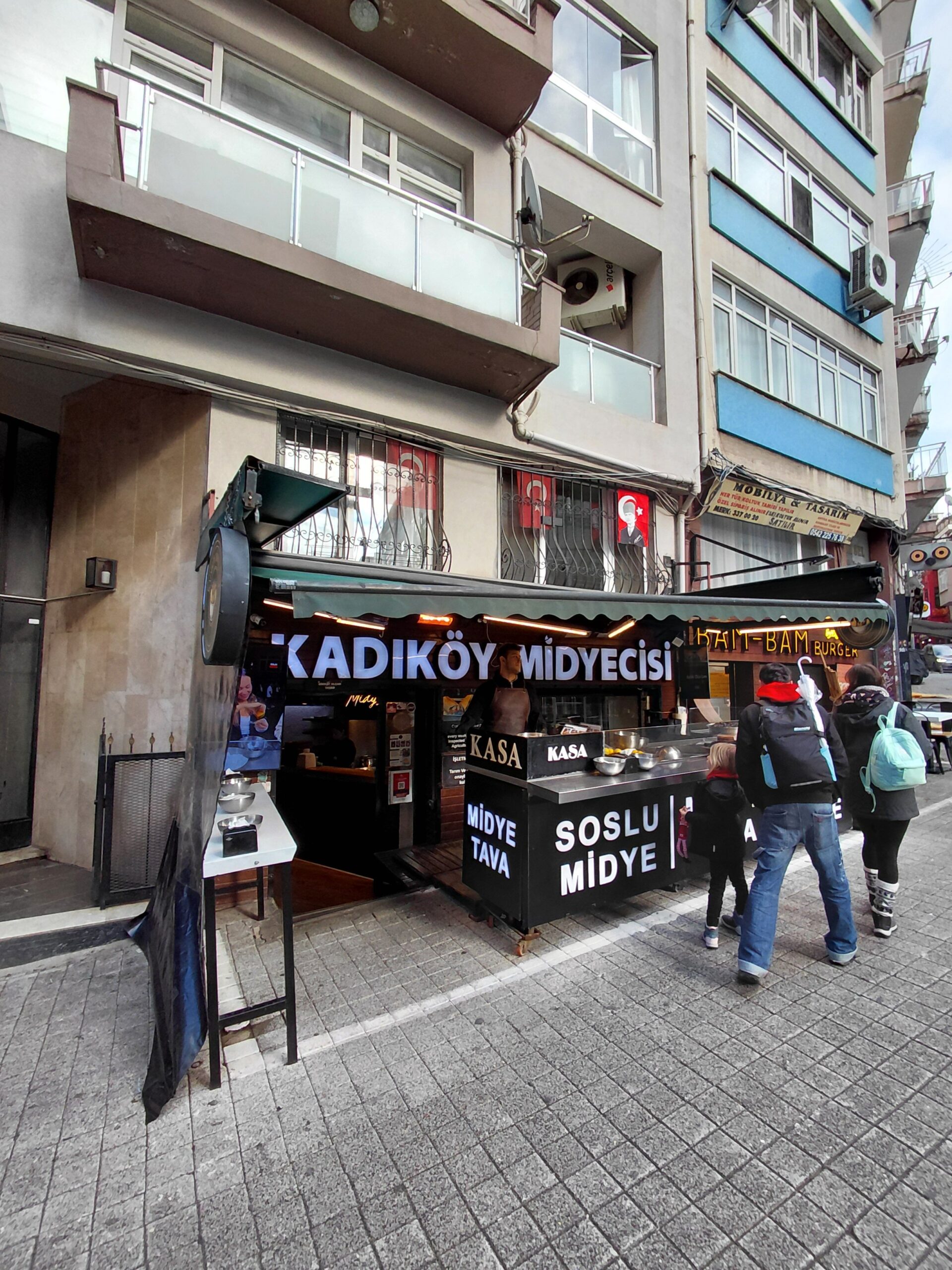 建物の前の歩道を歩く人々