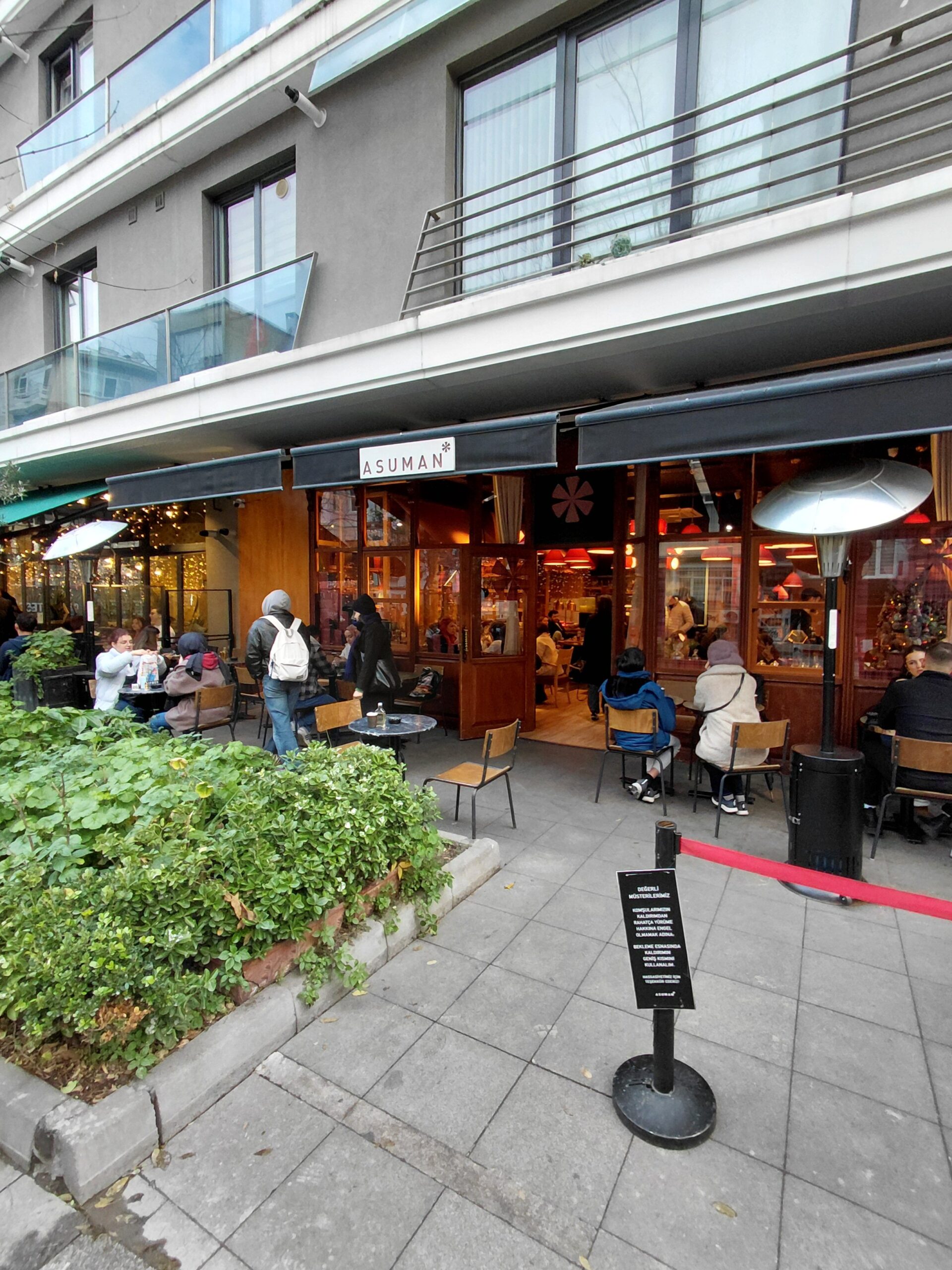 建物の前の歩道を歩く人々