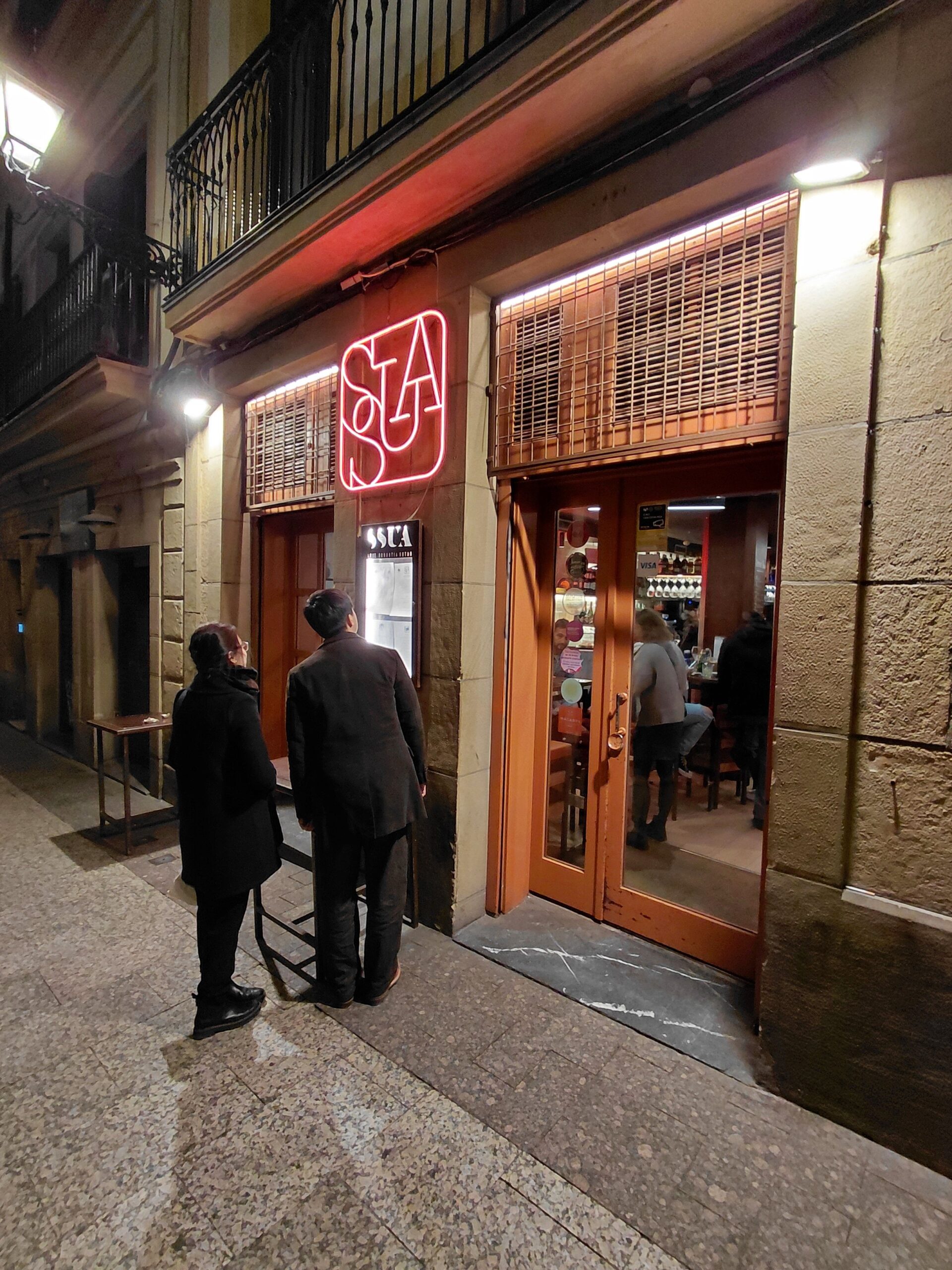 店の前の歩道を歩いている人