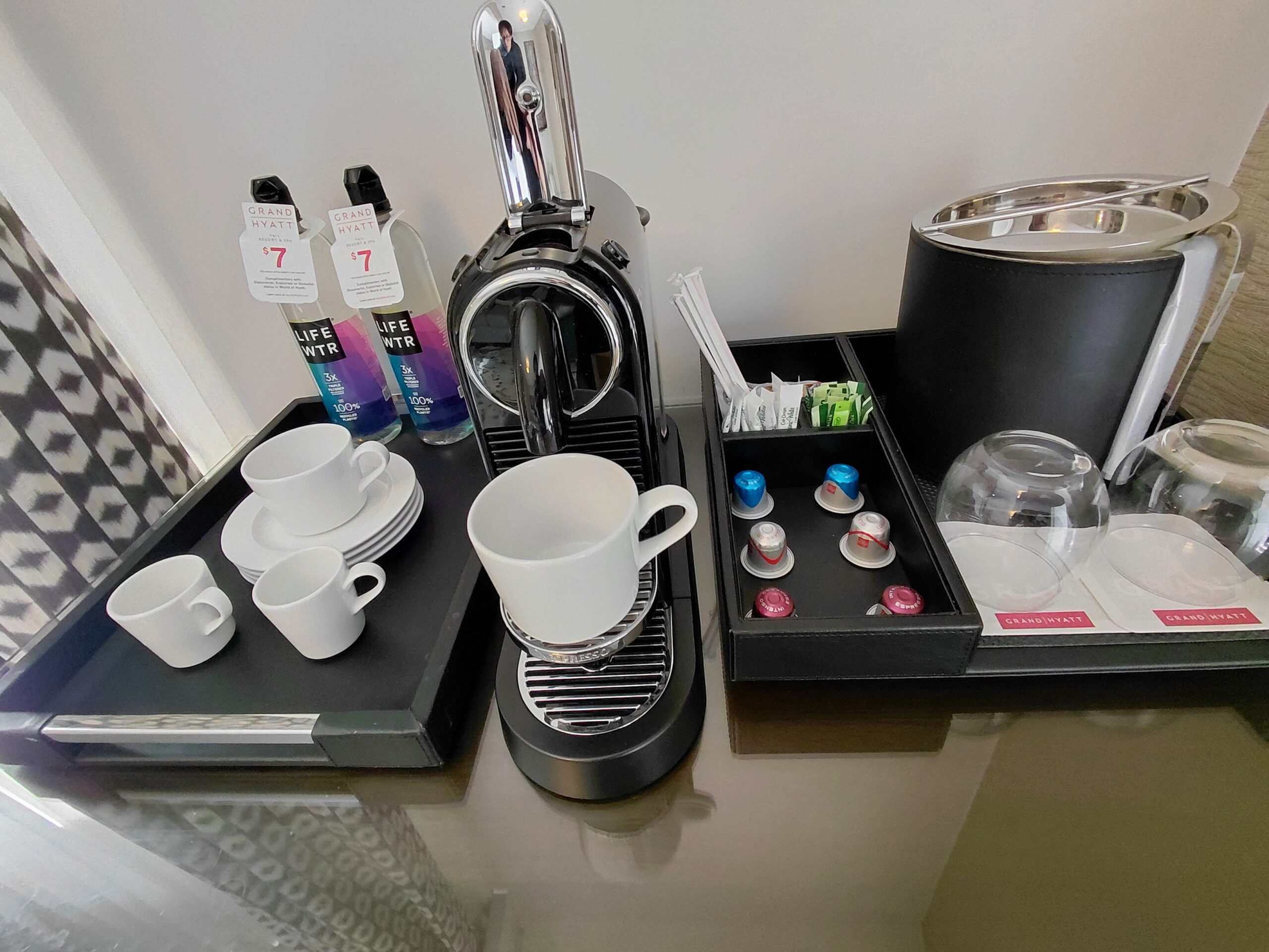 テーブルの上にある数種類のパンフレットとコーヒーメーカー